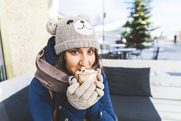 Portrait of woman drinking glass of hot chocolate with whipped cream - WPEF00618