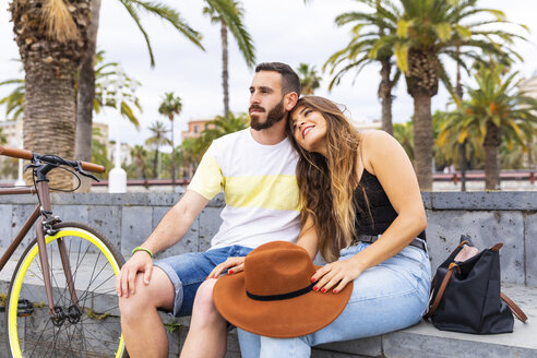 Spanien, Barcelona, zärtliches Paar sitzt auf einer Bank und entspannt sich - WPEF00625