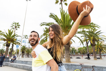 Spain, Barcelona, couple having fun on seaside promenade - WPEF00627