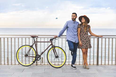 Spanien, Barcelona, Paar mit Fahrrad am Meer stehend - WPEF00629