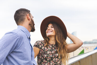 Spain, Barcelona, happy couple at the seaside looking at each other - WPEF00630