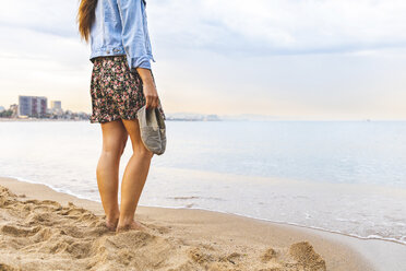 Spanien, Barcelona, Frau steht barfuß am Strand - WPEF00638