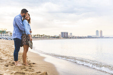 Spain, Barcelona, couple standing barefoot on the beach - WPEF00639