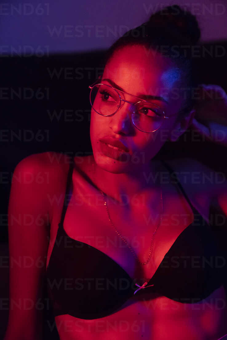 https://us.images.westend61.de/0000998079pw/portrait-of-beautiful-young-woman-wearing-bra-and-glasses-in-artificial-light-KKAF01139.jpg