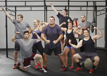 Portrait of eight people flexing muscles in gym - ISF16304