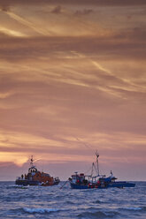 Rettungsboot rettet Fischerboot bei Sonnenaufgang, Tenby, Wales, UK - ISF16305