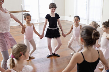 Kinder und Lehrer in einem Kreis beim Ballettunterricht in einer Ballettschule - ISF16347