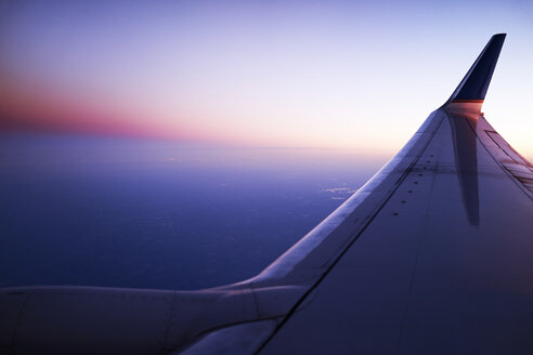 Erhöhte Ansicht von Flugzeugflügel und Himmel bei Sonnenuntergang - ISF16360