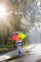 Junge mit Regenschirm und Blick auf die Straße - ISF16392