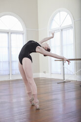 Teenage ballerina leaning back in ballet position at ballet school - ISF16423