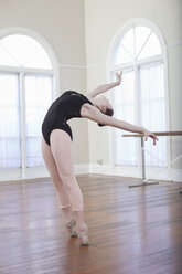Teenager-Ballerina lehnt sich in der Ballettposition in der Ballettschule zurück - ISF16423