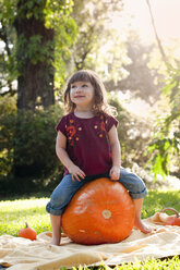 Girl sitting on pumpkin - ISF16439