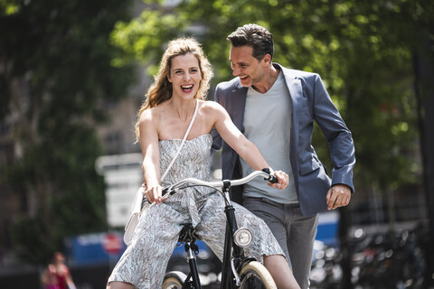 Glückliches sorgloses Paar mit Fahrrad in der Stadt, lizenzfreies Stockfoto