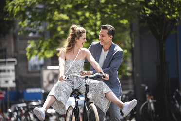 Glückliches sorgloses Paar mit Fahrrad in der Stadt - UUF14425