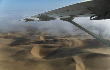 Aerial view of airplane wing over dunes, Namib Desert, Namibia - CUF38934