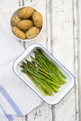 Organic green asparagus and jacket potatoes in bowl - LVF07222