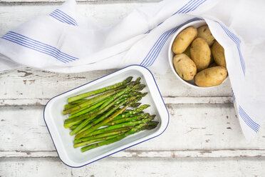 Organic green asparagus and jacket potatoes in bowl - LVF07223