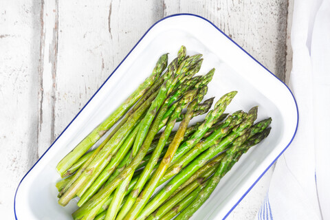 Boiled organic green asparagus in souffle dish stock photo