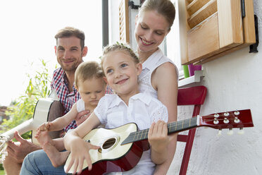 Mädchen spielt Gitarre mit Familie - CUF39023