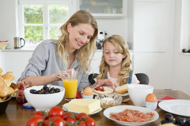 Mother and daughter eating at kitchen table - CUF39036