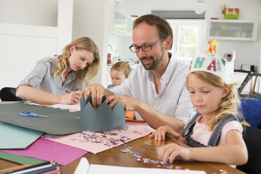 Familie bastelt Papierkronen - CUF39041