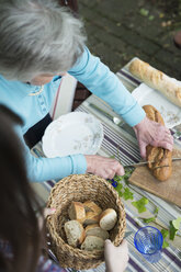 Ältere Frau beim Brotschneiden, hoher Winkel - CUF39141