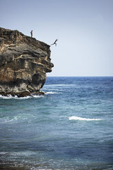 Mann springt von einer Klippe ins Meer, Poipu, Kaua'i, Hawaii, USA - ISF16505