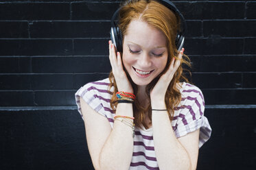 Portrait of young woman wearing headphones - ISF16519