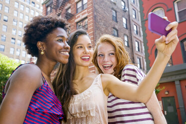 Drei junge Frauen fotografieren sich selbst mit einem Mobiltelefon - ISF16521