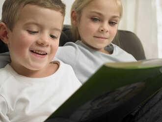 Kinder lesen gemeinsam auf dem Sofa - CUF39171