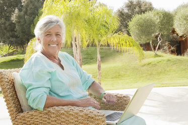 Ältere Frau benutzt Laptop im Freien - CUF39182