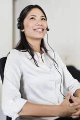 Businesswoman wearing headset at desk - CUF39204