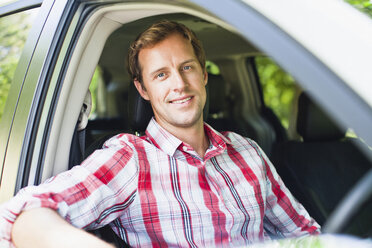 Smiling man sitting in car - CUF39234