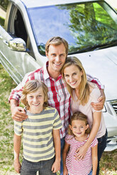 Family smiling together by car - CUF39240