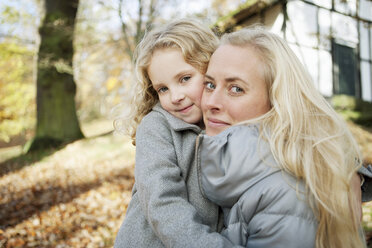 Mother and daughter hugging outdoors - CUF39250