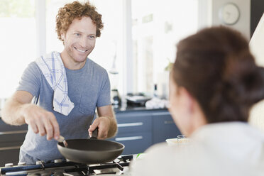 Man cooking for girlfriend in kitchen - CUF39261
