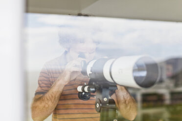 Mann mit Teleskop am Fenster - CUF39275