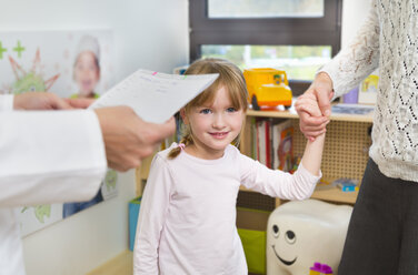 Girl holding hands with mother at dentists - CUF39408