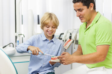 Zahnarzt lehrt Junge, wie man Zähne putzt - CUF39416