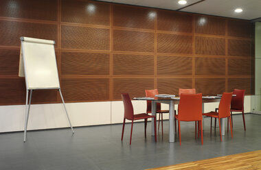 Flipchart and red chairs in conference room - CUF39563