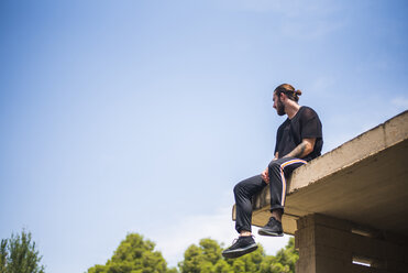 Tattooed man sittin on roof top - ACPF00092