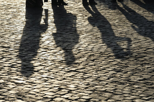 Italien, Rom, Schatten von Menschen auf Kopfsteinpflaster - RUEF01893