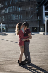 Affectionate young couple standing on city square - MAUF01449