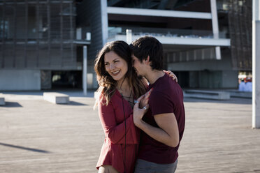 Happy affectionate young couple standing on city square - MAUF01450