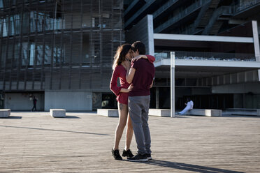 Affectionate young couple standing on city square - MAUF01451