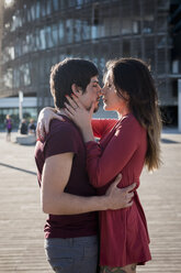 Affectionate young couple standing on city square - MAUF01453