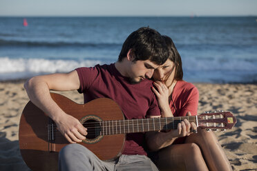 Paar mit einer Gitarre am Strand sitzend - MAUF01464