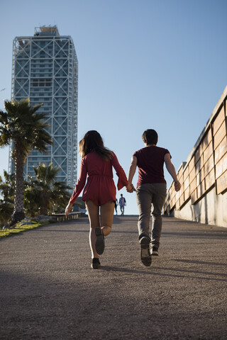 Spanien, Barcelona, Paar läuft Hand in Hand durch die Stadt, lizenzfreies Stockfoto