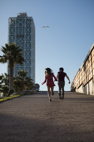 Spanien, Barcelona, Paar läuft Hand in Hand durch die Stadt, lizenzfreies Stockfoto