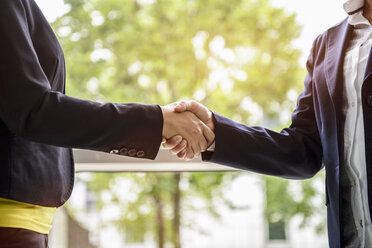 Mature businesswoman shaking hands with young female client - ISF16538